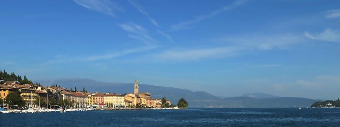 Trip Tuerkei beliebte Urlaubsziele am Gardasee -  Mit einer Fläche von 370 km² ist der Gardasee der größte See Italiens. Es liegt am Fuße der Alpen und erstreckt sich über drei Staaten: Lombardei, Venetien und Trentino. Die maximale Tiefe des Sees beträgt 346 m, er hat eine längliche Form und sein nördliches Ende ist sehr schmal. Dort ist der See von den Bergen der Gruppo di Baldo umgeben. Du trittst aus deinem gemütlichen Hotelzimmer und es begrüßt dich die warme italienische Sonne. Du blickst auf den atemberaubenden Gardasee, der in zahlreichen Blautönen schimmert - von tiefem Dunkelblau bis zu funkelndem Türkis. Majestätische Berge umgeben dich, während die Brise sanft deine Haut streichelt und der Duft von blühenden Zitronenbäumen deine Nase kitzelt. Du schlenderst die malerischen, engen Gassen entlang, vorbei an farbenfrohen, blumengeschmückten Häusern. Vereinzelt unterbricht das fröhliche Lachen der Einheimischen die friedvolle Stille. Du fühlst dich wie in einem Traum, der nicht enden will. Jeder Schritt führt dich zu neuen Entdeckungen und Abenteuern. Du probierst die köstliche italienische Küche mit ihren frischen Zutaten und verführerischen Aromen. Die Sonne geht langsam unter und taucht den Himmel in ein leuchtendes Orange-rot - ein spektakulärer Anblick.